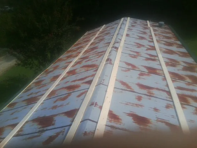 Rusted metal roof panels with new wood purlins before replacement — Storm Damage Roof Repair in Clymer by Roofing Brothers