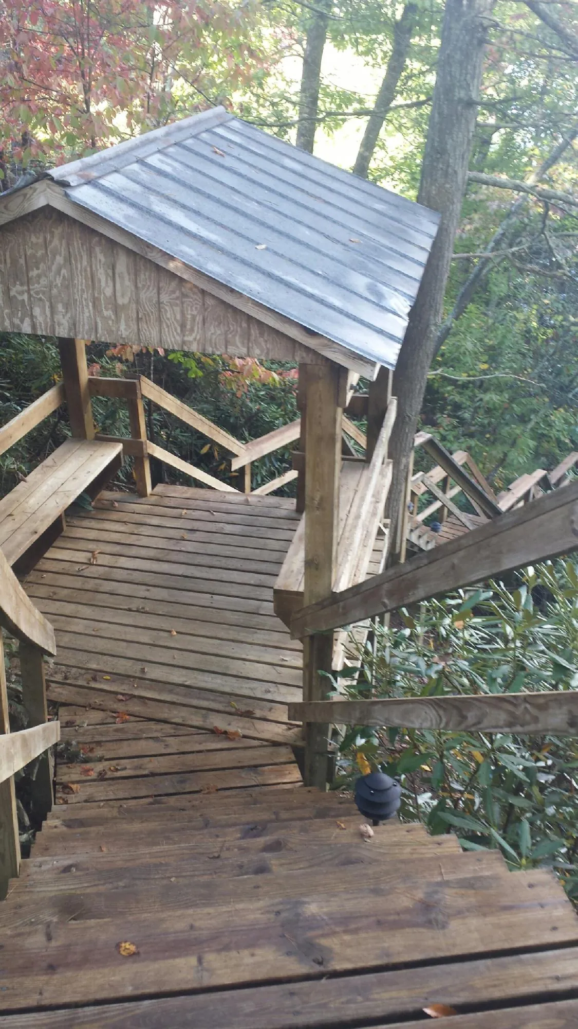 Metal roofed shelter over wooden steps on a wooded walkway — Skylight Repair & Installation work by our crew in Clymer