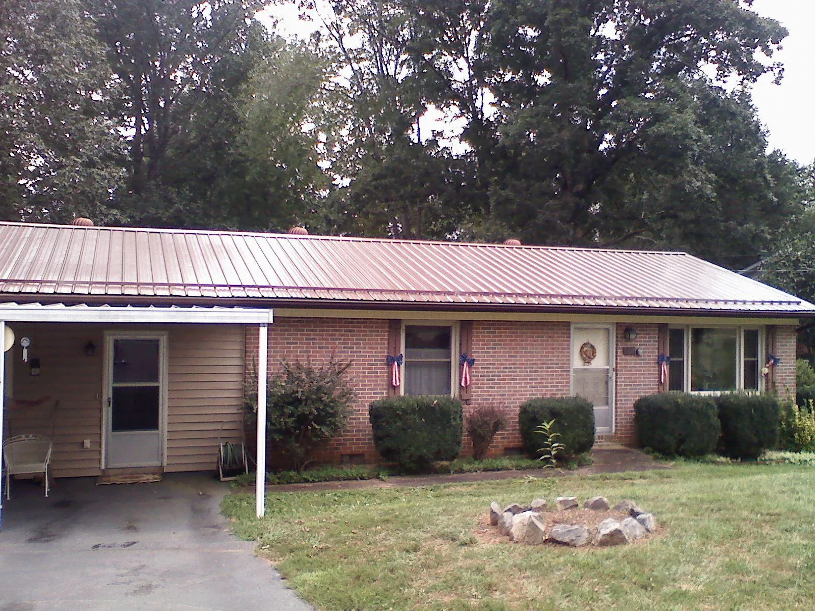 Bronze metal roof and carport on a brick ranch home — Roof Repair work by our crew in Clymer